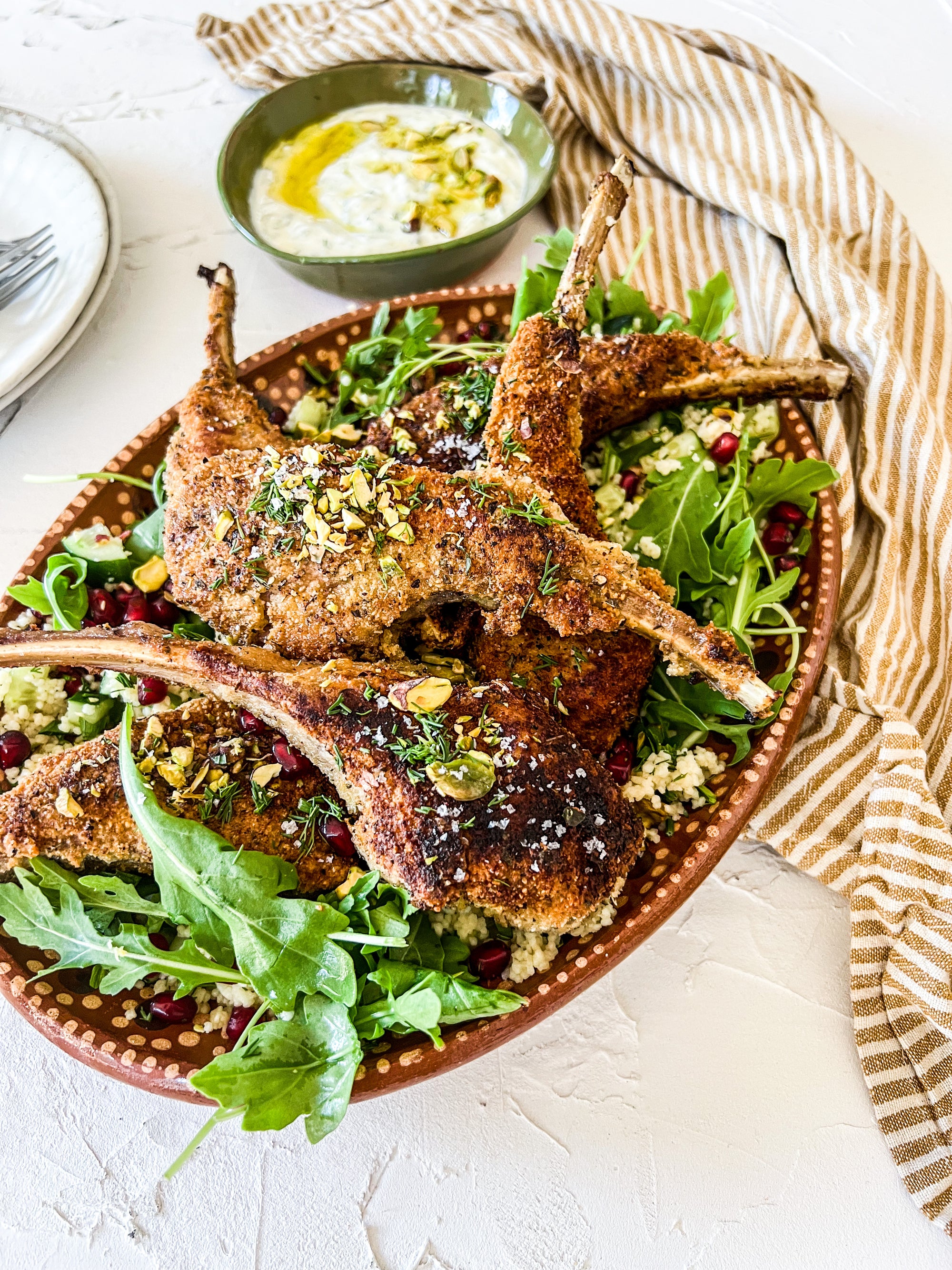 Almond crumbed lamb cutlets on herby couscous with mint and dill yoghurt dressing