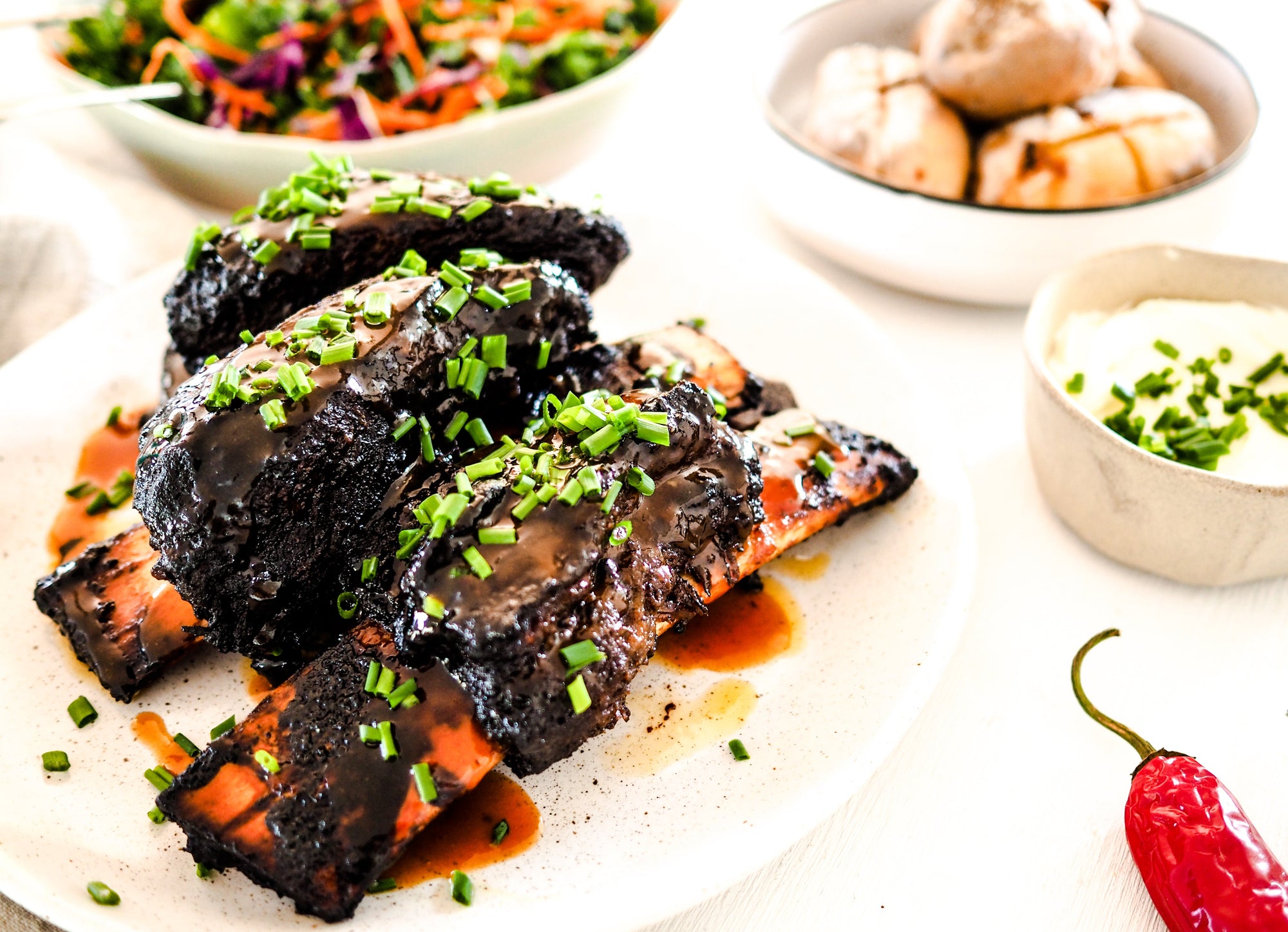 Spiced Sticky Beef Ribs with Baked Potatoes, Sour Cream, Chives & Slaw